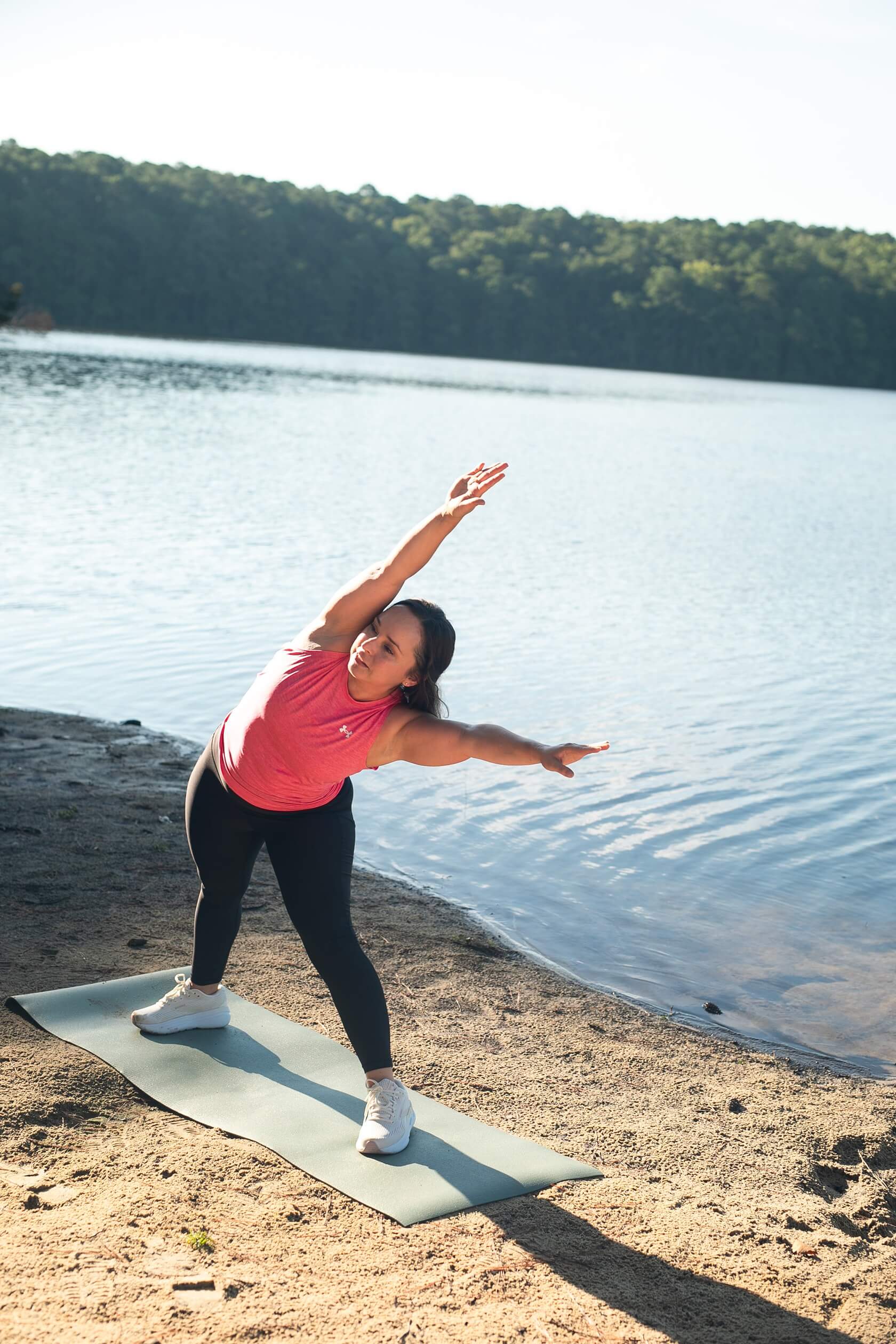 Fitness personal trainer for women, Coach Lil, working out outside stretching on yoga mat.
